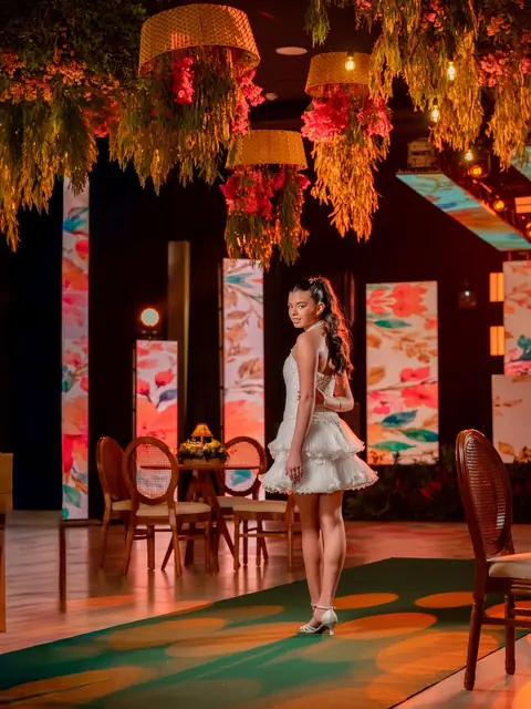 Quinceañera en el salón decorado con plantas colgantes