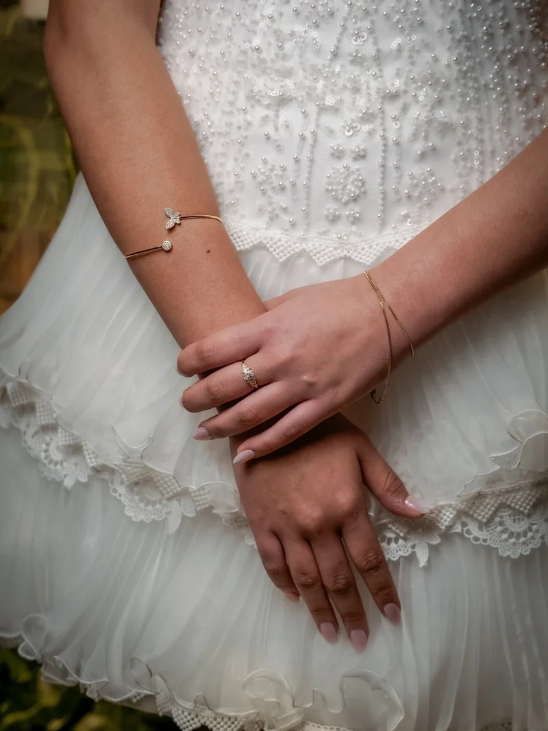 Manos de la quinceañera sobre su vestido de volados