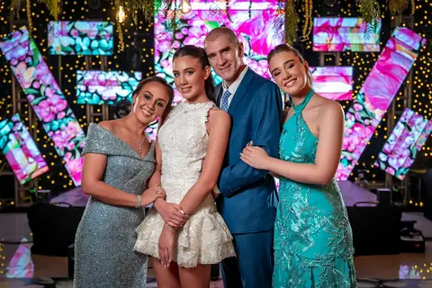 Quinceañera con su familia frente a las pantallas